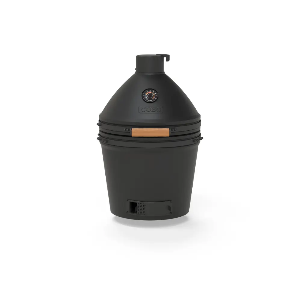 Kamado céramique en cuisson lente avec un filet de fumée sortant de l'évent supérieur
